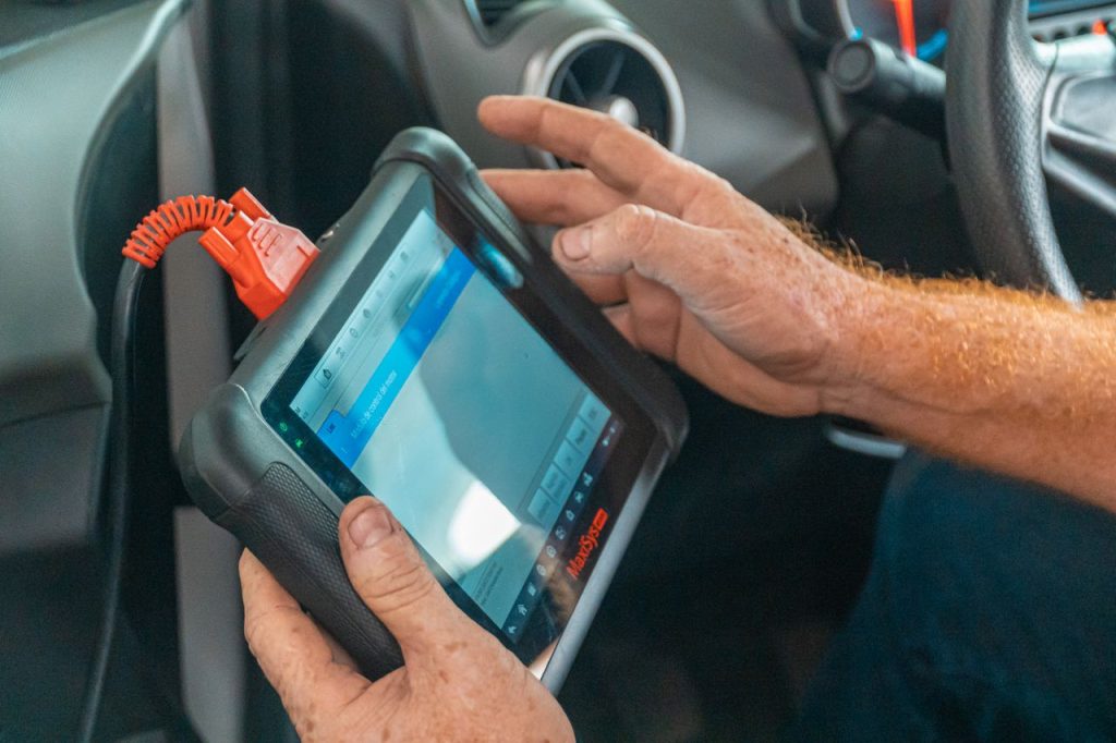 pexels photo 4116198 4116198 A mechanic uses a diagnostic tablet inside a car for vehicle analysis.